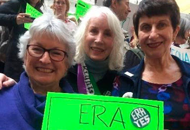 Three women holding ERA sign