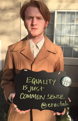 Teenage boy holding Equality ERA utah sign