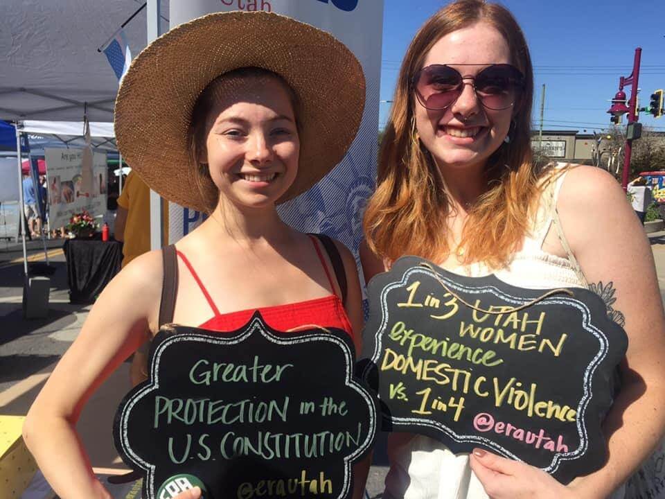 Two teenagers holding ERA Utah signs